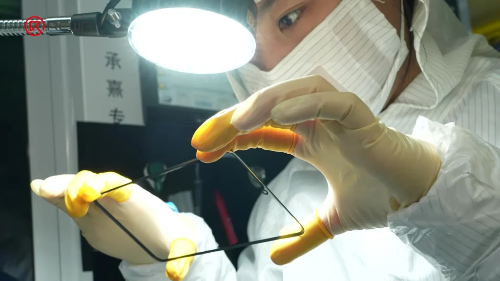 Un trabajador con mascarilla inspecciona una pantalla de posventa de Samsung.