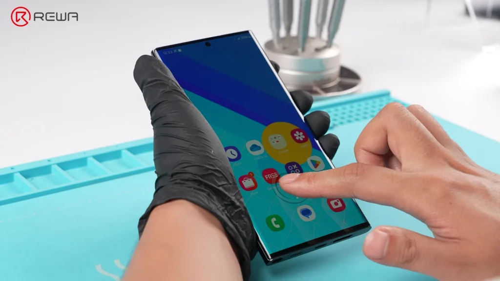 Un dito attiva il sensore di impronte digitali sotto il display su uno smartphone Samsung con uno schermo OLED non originale