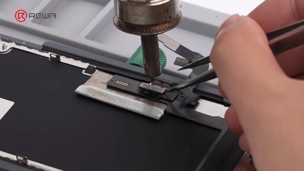 Techniker führt komplexe Mikrolötung an einem iPhone-Bildschirm-Chip mit einem Heißluftföhn und einer Pinzette durch
