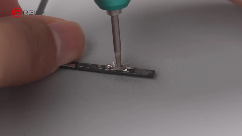 Ein Techniker, der ein Präzisionswerkzeug an einer kleinen elektronischen Komponente benutzt, was komplexe Mikrolötarbeiten veranschaulicht