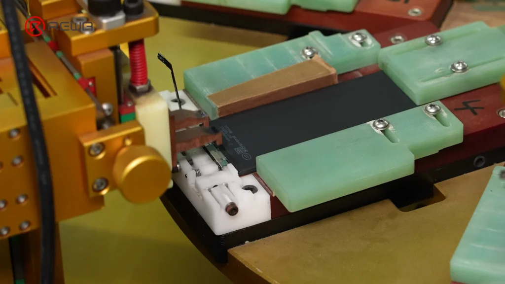Automated spot welding equipment connecting a battery cell to a BMS board held in an assembly fixture