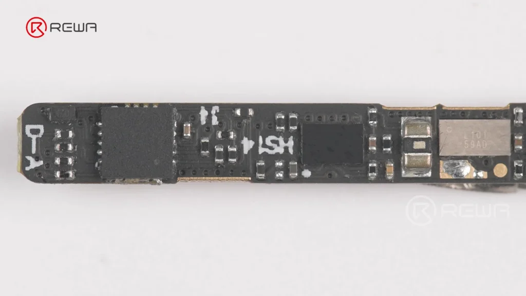Close-up view of a populated black iPhone battery BMS circuit board with surface-mounted chips and electronic components